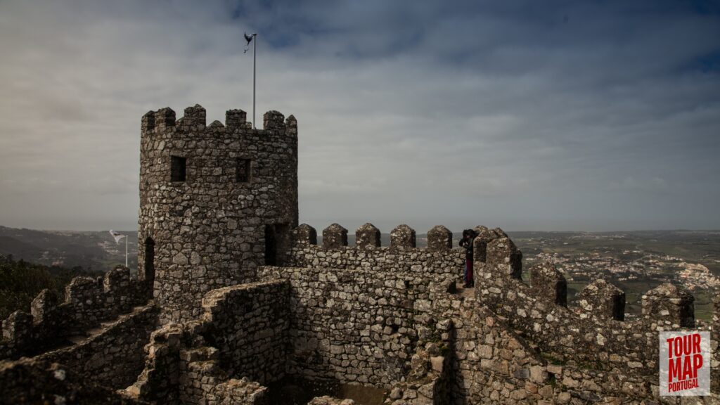 Historic walls and towers of the Moorish Castle in Sintra. Built in the 8th century, this ancient fortress stands as a testament to Sintra’s rich history. Its rugged walls and towers provide breathtaking views over Sintra and the surrounding forests, blending natural beauty with historical significance with Tour Map Portugal.