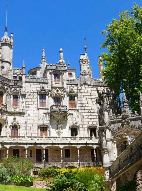 Gothic architecture and lush gardens of Quinta da Regaleira. Known for its elaborate Gothic-style architecture and enigmatic gardens, this UNESCO site is filled with hidden tunnels, lakes, and the iconic Initiation Well, offering an otherworldly experience steeped in symbolism and mystery with Tour Map Portugal.