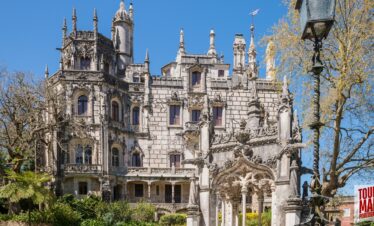 Gothic architecture and lush gardens of Quinta da Regaleira. Known for its elaborate Gothic-style architecture and enigmatic gardens, this UNESCO site is filled with hidden tunnels, lakes, and the iconic Initiation Well, offering an otherworldly experience steeped in symbolism and mystery with Tour Map Portugal.