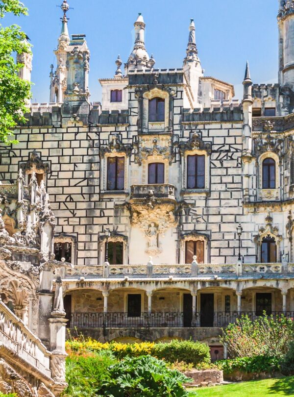 Gothic architecture and lush gardens of Quinta da Regaleira. Known for its elaborate Gothic-style architecture and enigmatic gardens, this UNESCO site is filled with hidden tunnels, lakes, and the iconic Initiation Well, offering an otherworldly experience steeped in symbolism and mystery with Tour Map Portugal.